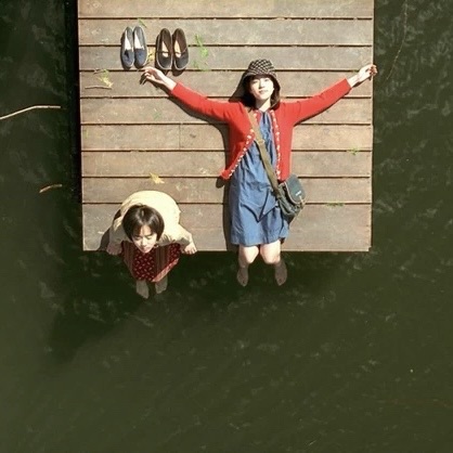 A Tale of Two Sisters – dwie siostry na drewnianym pomoście nad jeziorem, jedna leży, druga siedzi – kadr z filmu Kim Jee-woona